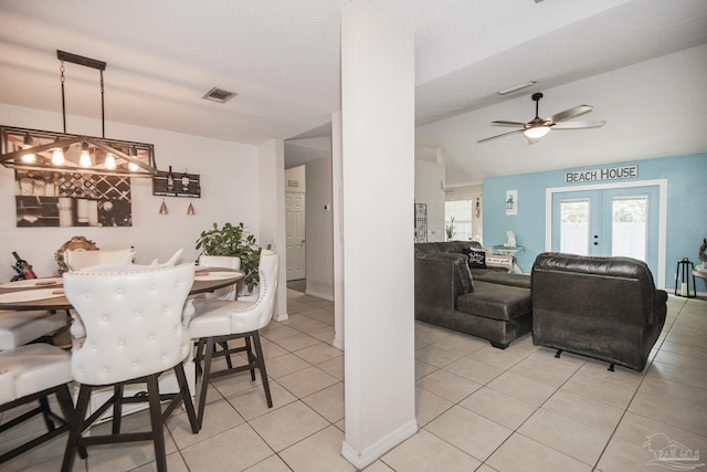 dining space with ceiling fan, french doors, light tile patterned floors, lofted ceiling, and visible vents