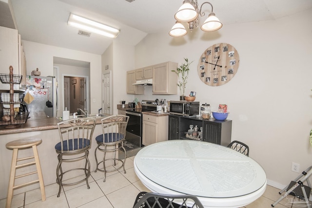 kitchen with vaulted ceiling, light tile patterned floors, a chandelier, light brown cabinets, and stainless steel appliances