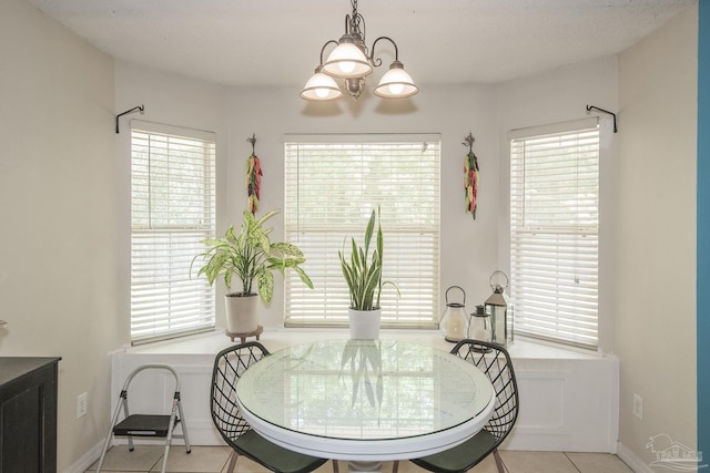 dining space with tile patterned floors, plenty of natural light, baseboards, and a notable chandelier