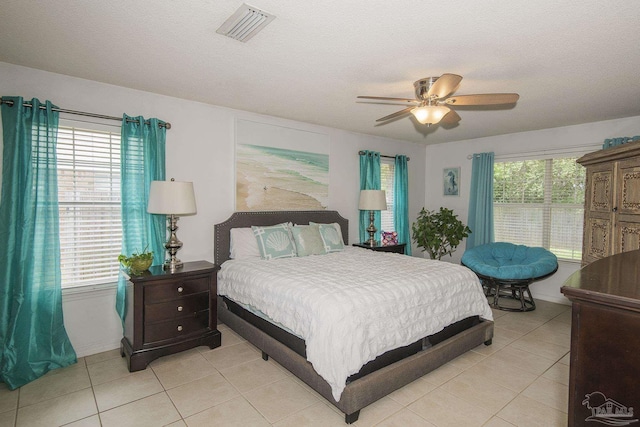 bedroom with light tile patterned floors, multiple windows, and visible vents
