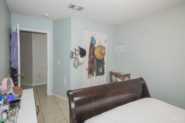 bedroom featuring visible vents, baseboards, and light tile patterned floors