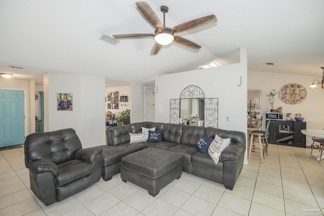 living area featuring light tile patterned floors, vaulted ceiling, a ceiling fan, and visible vents