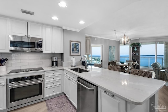 kitchen with sink, white cabinetry, stainless steel appliances, a water view, and kitchen peninsula