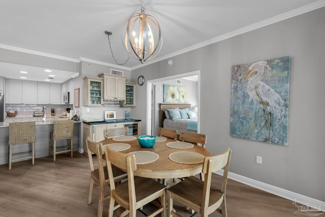 dining space featuring ornamental molding, hardwood / wood-style floors, wine cooler, and a chandelier