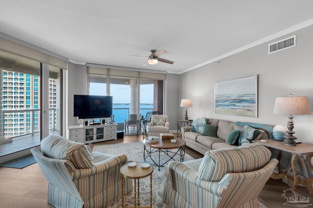 living room with crown molding, ceiling fan, and light hardwood / wood-style floors