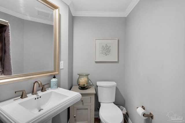 bathroom with sink, crown molding, and toilet