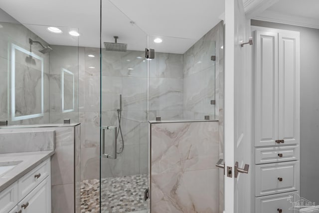 bathroom with vanity, an enclosed shower, and crown molding