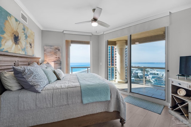 bedroom featuring multiple windows, access to outside, ornamental molding, and light wood-type flooring