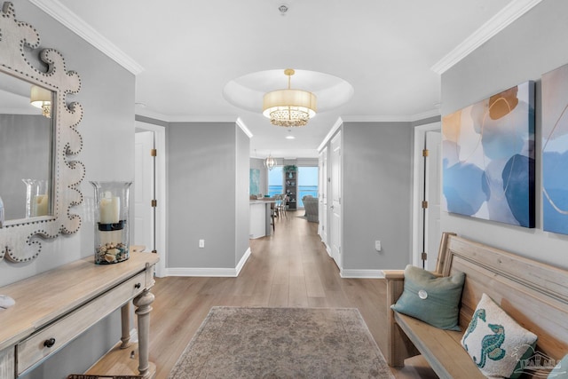 hall with crown molding, a chandelier, and light wood-type flooring