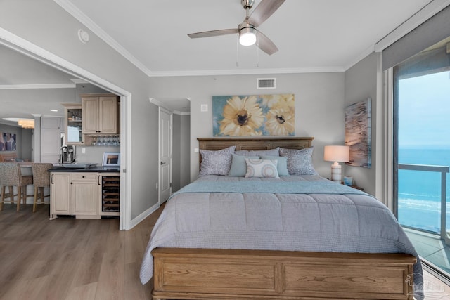 bedroom with wine cooler, a water view, light wood-type flooring, ornamental molding, and ceiling fan