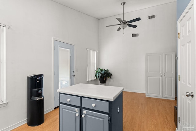 28 Easton St, Cantonment, FL 32533 - kitchen featuring ceiling fan, a high ceiling, light wood-style floors, a center island, and light countertops