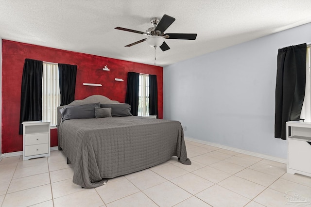 28 Easton St, Cantonment, FL 32533 - bedroom with an accent wall, baseboards, ceiling fan, a textured ceiling, and light tile patterned flooring