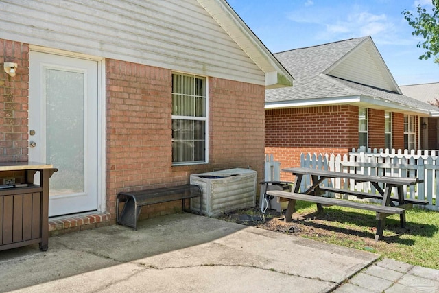 28 Easton St, Cantonment, FL 32533 - back of property with brick siding, roof with shingles, and a patio area