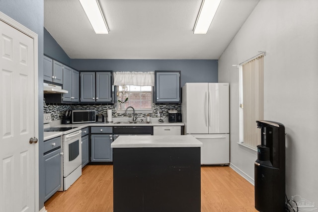 28 Easton St, Cantonment, FL 32533 - kitchen featuring white appliances, a sink, under cabinet range hood, light countertops, and light wood-style flooring