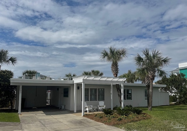 1207 Ariola Dr, Pensacola Beach, FL 32561 - view of front facade featuring an attached carport, driveway, a front lawn, and covered porch