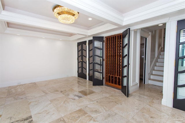 interior space with crown molding, a tray ceiling, and a chandelier