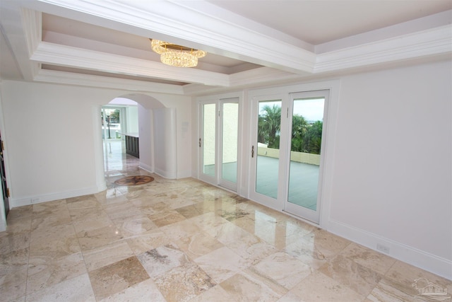 empty room featuring ornamental molding, a tray ceiling, and an inviting chandelier