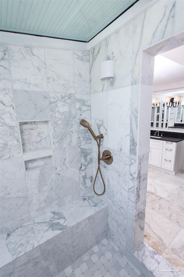 bathroom with vanity and a tile shower