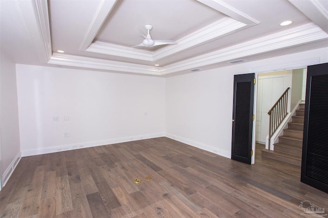 spare room with ornamental molding, a tray ceiling, dark hardwood / wood-style floors, and ceiling fan