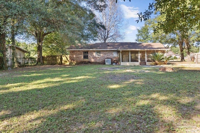 rear view of property with a lawn, a sunroom, and central air condition unit