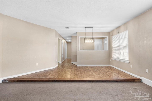 empty room with wood-type flooring and a textured ceiling