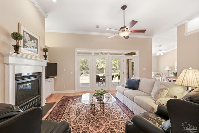 living area with visible vents, a fireplace with flush hearth, ornamental molding, french doors, and light wood finished floors