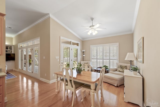 dining room featuring french doors, light wood-style floors, crown molding, lofted ceiling, and ceiling fan