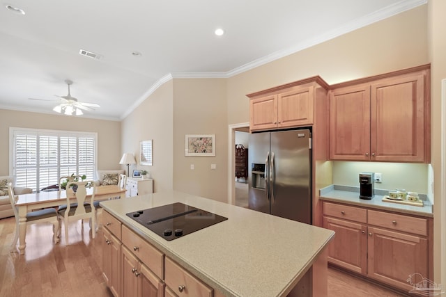 kitchen with light wood finished floors, stainless steel fridge, crown molding, black electric cooktop, and open floor plan