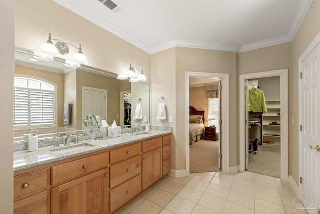 bathroom featuring a sink, visible vents, crown molding, and tile patterned flooring