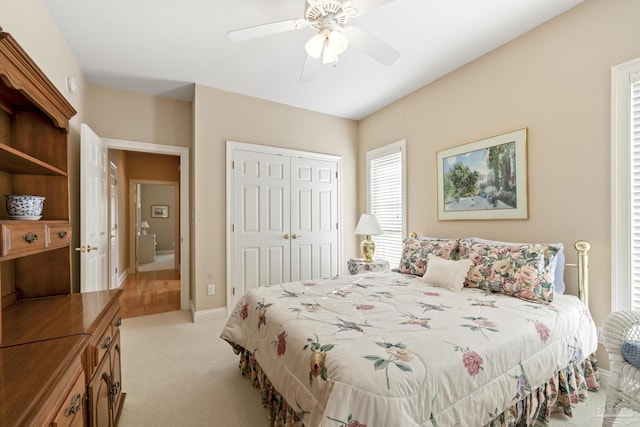 bedroom with ceiling fan, a closet, and light carpet