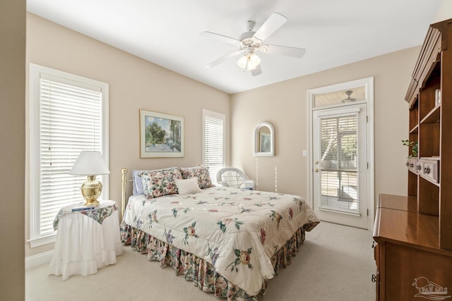 bedroom with access to exterior, carpet flooring, and a ceiling fan