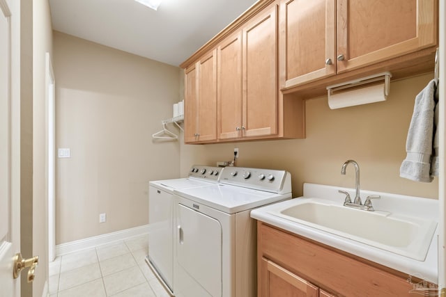 laundry room with light tile patterned floors, baseboards, cabinet space, separate washer and dryer, and a sink