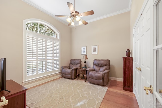 living area with a wealth of natural light, baseboards, light wood-style floors, and crown molding