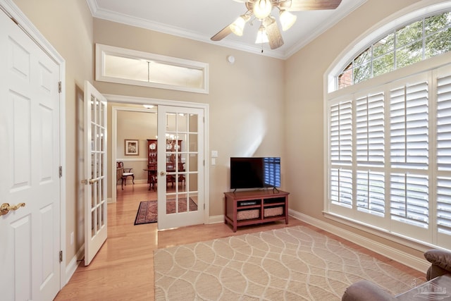 sitting room featuring crown molding, light wood-style flooring, french doors, and a wealth of natural light