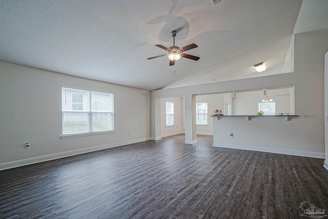 257 Millet Cir, Cantonment, FL 32533 - unfurnished living room featuring ceiling fan, vaulted ceiling, dark wood-style floors, and a textured ceiling