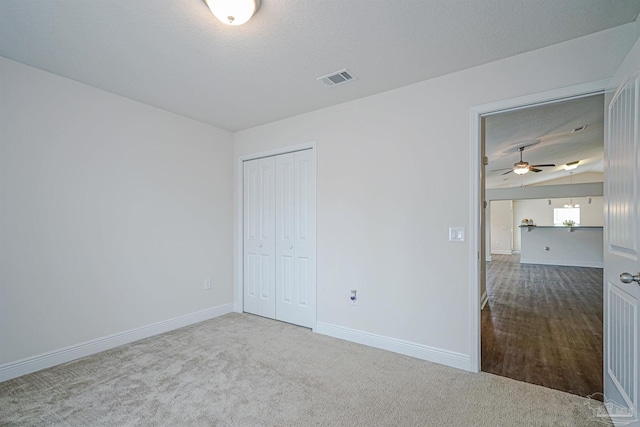 257 Millet Cir, Cantonment, FL 32533 - unfurnished bedroom featuring a closet, lofted ceiling, baseboards, a textured ceiling, and carpet flooring