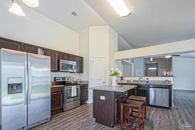 257 Millet Cir, Cantonment, FL 32533 - kitchen featuring dark brown cabinetry, visible vents, high vaulted ceiling, stainless steel appliances, and dark wood-type flooring