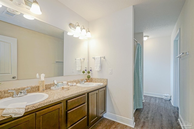 257 Millet Cir, Cantonment, FL 32533 - bathroom featuring double vanity, baseboards, a sink, and wood finished floors