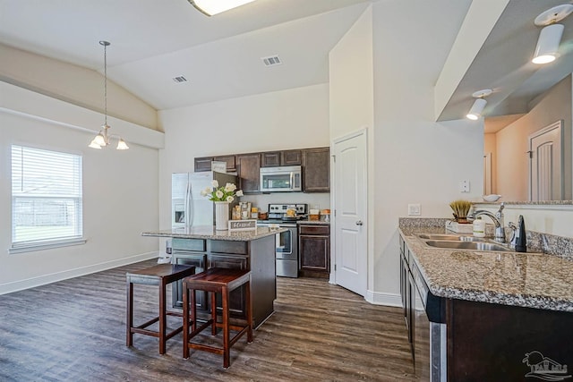 257 Millet Cir, Cantonment, FL 32533 - kitchen with dark brown cabinetry, a kitchen bar, a sink, dark wood finished floors, and stainless steel appliances