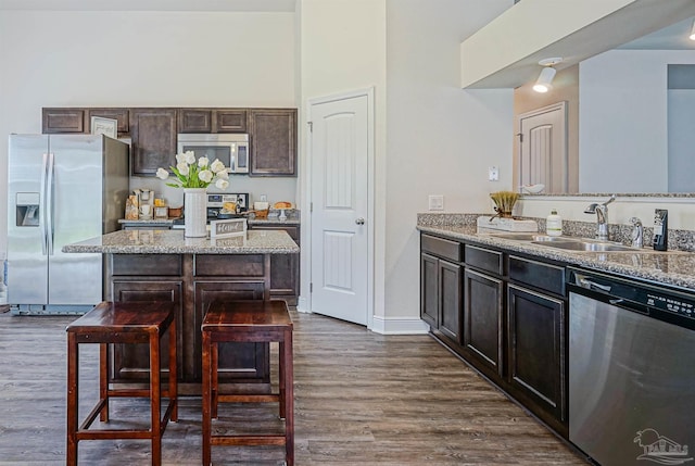 257 Millet Cir, Cantonment, FL 32533 - kitchen with dark wood-style flooring, dark brown cabinets, light stone counters, appliances with stainless steel finishes, and a sink