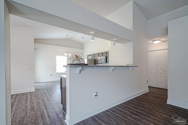 257 Millet Cir, Cantonment, FL 32533 - kitchen with a peninsula, a kitchen breakfast bar, stainless steel microwave, and dark wood-style floors
