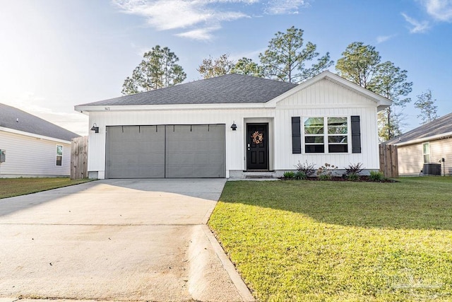 view of front of home featuring a front lawn, central AC unit, and a garage