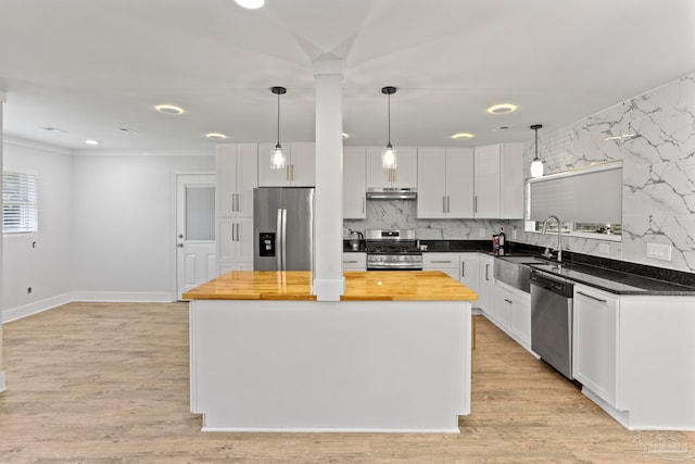 kitchen featuring appliances with stainless steel finishes, light wood-type flooring, backsplash, and white cabinetry