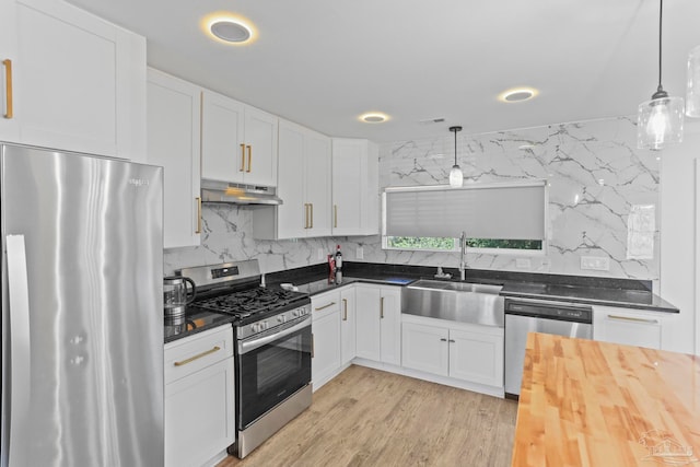 kitchen featuring sink, white cabinetry, backsplash, and stainless steel appliances