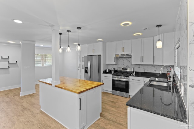 kitchen featuring white cabinets, stainless steel appliances, light hardwood / wood-style floors, and a center island