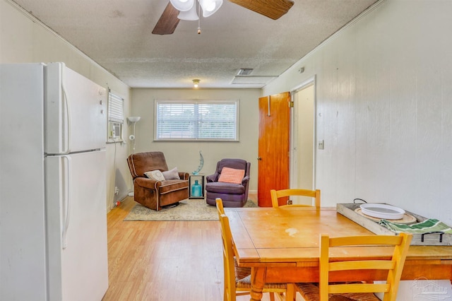 dining space featuring a textured ceiling, light hardwood / wood-style flooring, and ceiling fan