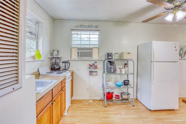 kitchen featuring light hardwood / wood-style floors, ceiling fan, plenty of natural light, and white appliances