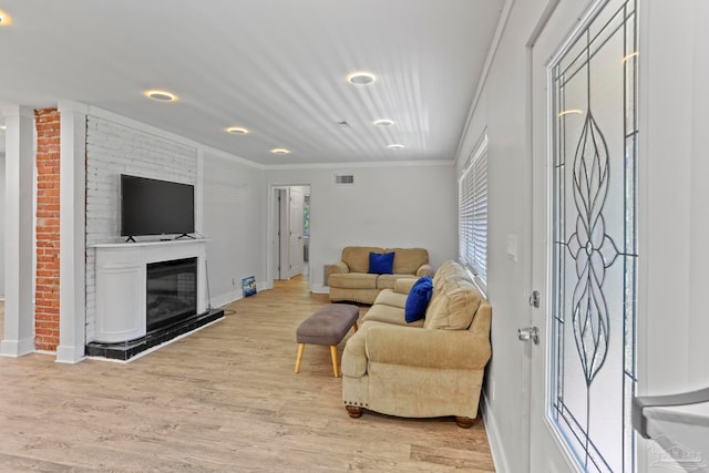 living room featuring light hardwood / wood-style flooring and crown molding