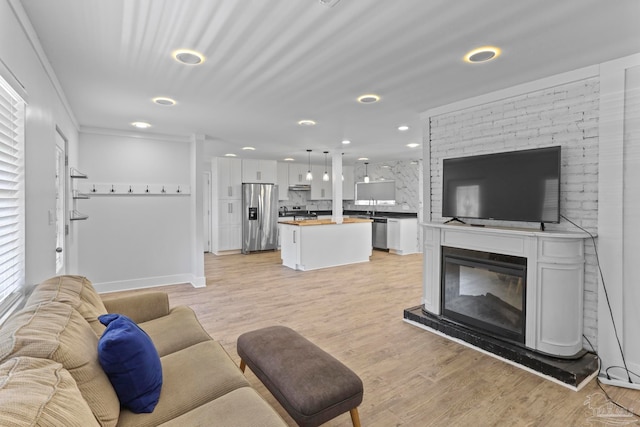 living room featuring crown molding and light hardwood / wood-style flooring