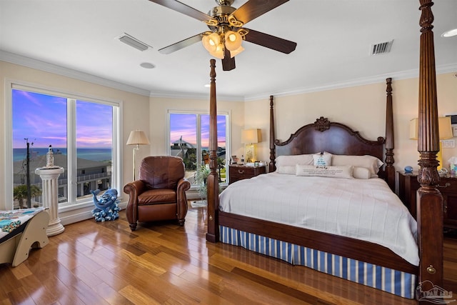 bedroom with multiple windows, hardwood / wood-style floors, ceiling fan, and ornamental molding